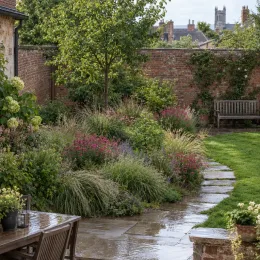 Gaura compacte rose 'Sel belleza dark pink' (Gaura lindheimeri) — massif fleuri le long d’une allée de jardin · Photo d'illustration
